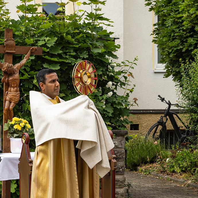 Pfarrvikar Joseph erteilt vor dem vierten Altar den eucharistischen Segen, links hinter ihm der Altar, rechts im Bild eine Ministrantin